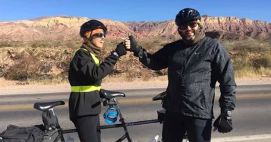 Padre e hijo pedaleando juntos en bicicleta tándem durante un viaje de cicloturismo inclusivo