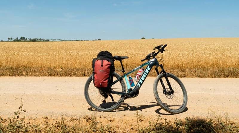 Bicicleta de cicloturismo equipada con alforjas impermeables en una ruta de montaña.